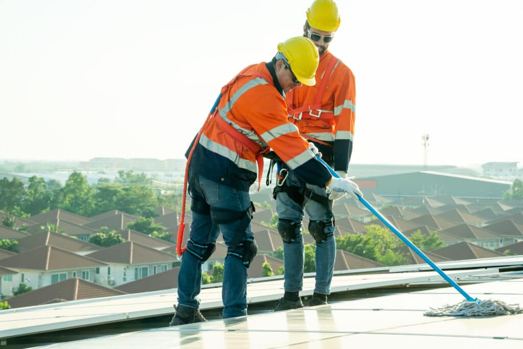 two maintenance workers checking for signs your flat roof has a hidden leak - Select FRR